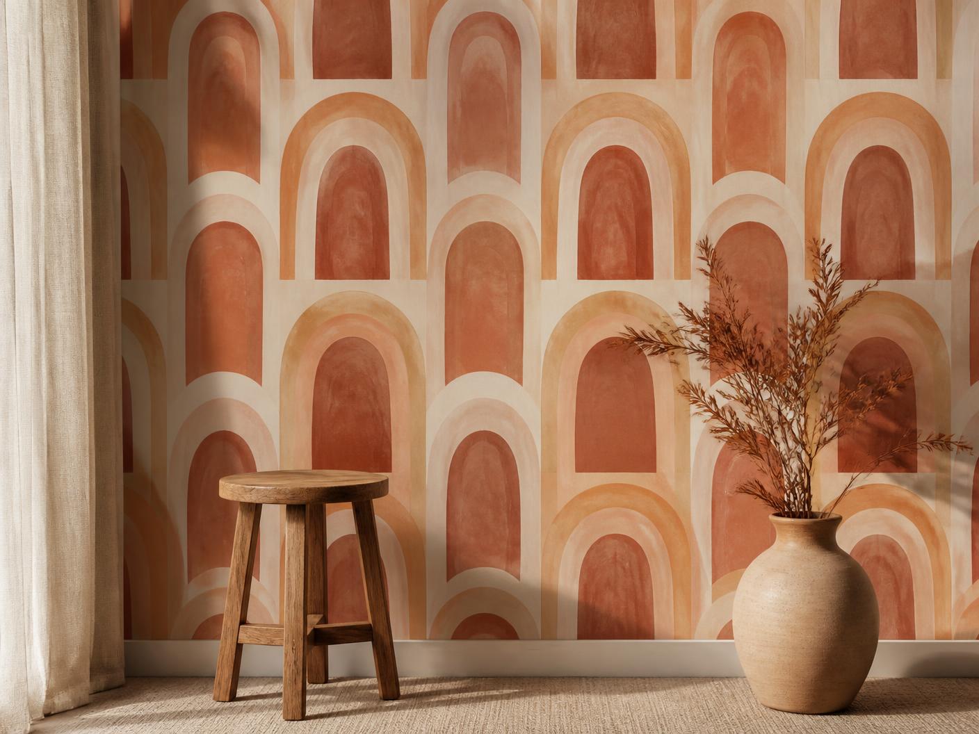 Wallpaper printed with a terracotta arch repeat behind a wooden stool and ceramic vase